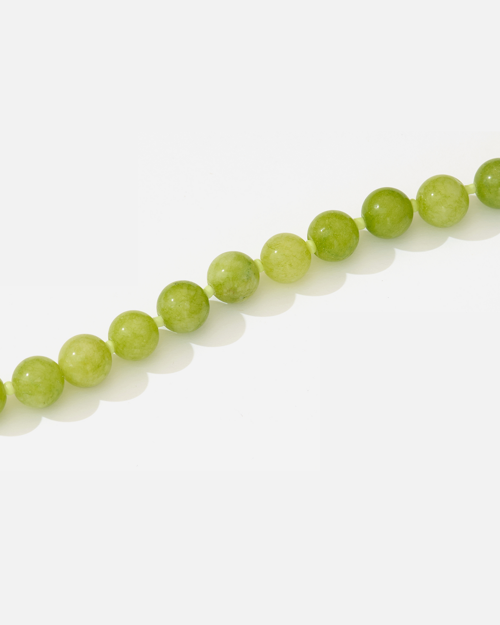 “Close-up of green agate beads – natural stones used in Sun Muse Emma necklace.”
